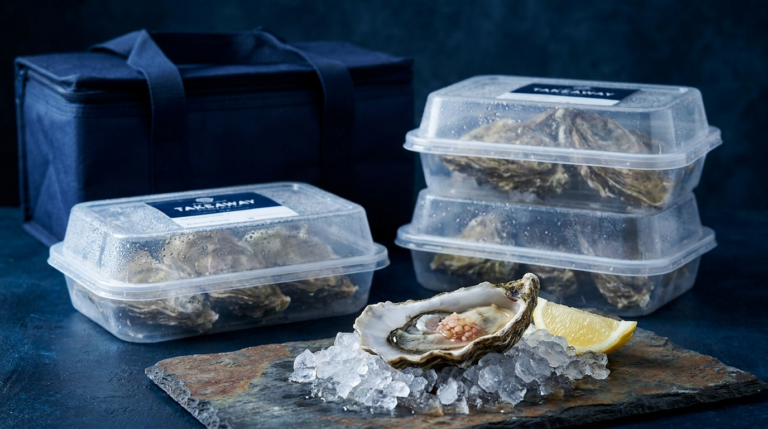 Packaged fresh oysters with one shucked oyster on ice